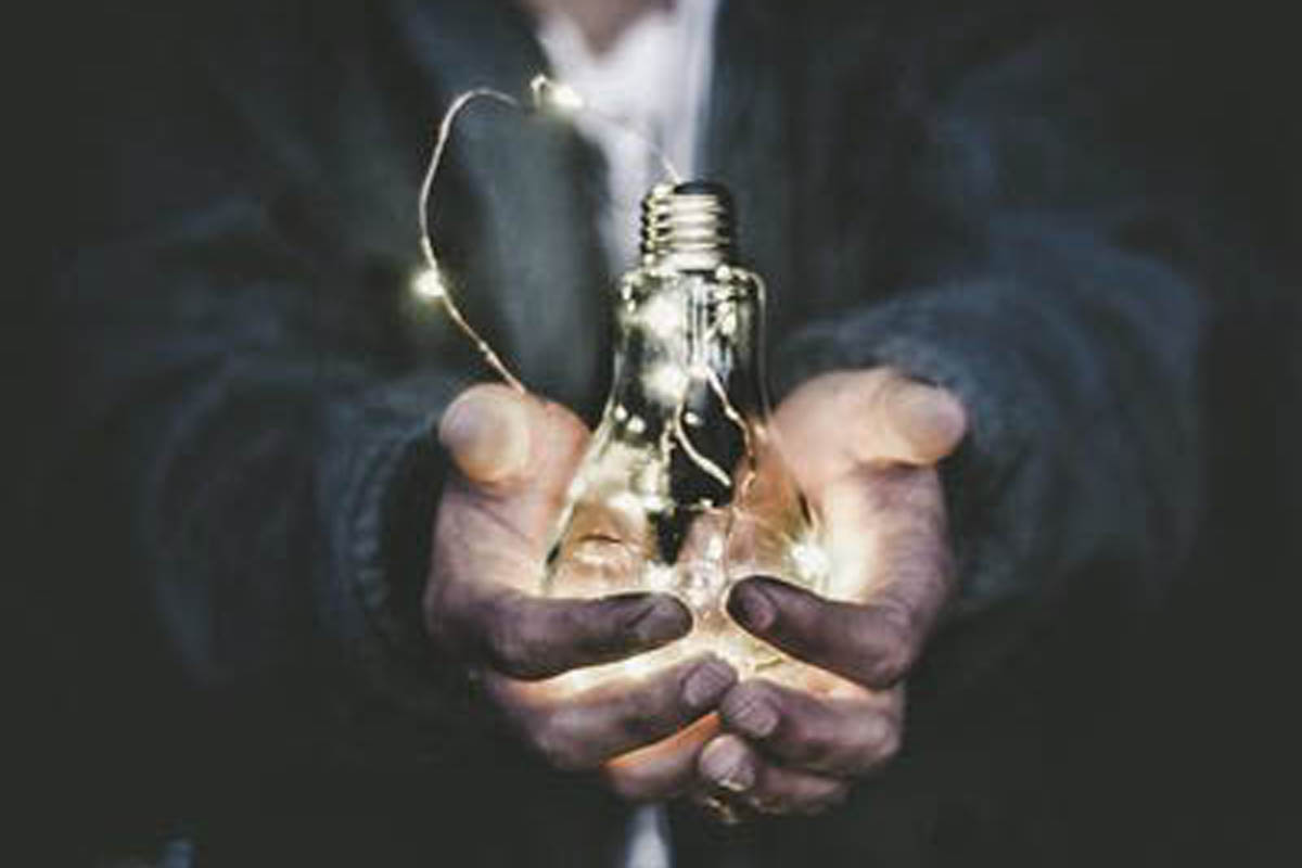 Photo of man holding lightbulb by Riccardo Annandale